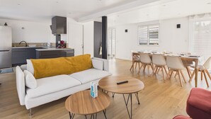 Un espacio moderno para vivir con sofá, mesa de centro, mesa de comedor y sillas.