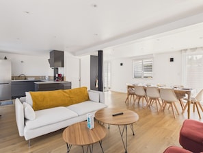 Un espace de vie moderne comprenant un canapé, une table basse, une table à manger et des chaises.