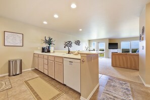 A modern kitchen with a dishwasher, a coffee maker, and a potted plant. - 212 - Life's a beach, take a paws and relax (Westport)
