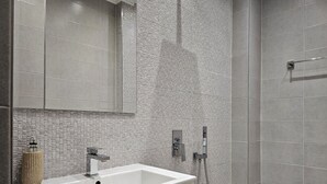 A bathroom with a white sink, a mirror, a shower, and a toilet. - Stylish&Beutiful
Vitosha Blvd (Sofia)