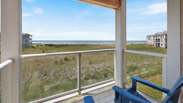 Ein Balkon mit Blick auf Strand und Gebäude.
