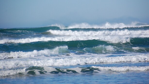 Une plage avec des vagues et un ciel dégagé.