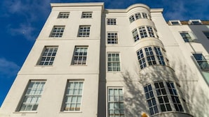 A multi-story building with a curved corner, large windows, and a clear sky. - Safestay Brighton Royal Pavilion (Brighton)