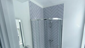 A modern bathroom with a glass-enclosed shower, a white sink, and a toilet. - Safestay Brighton Royal Pavilion (Brighton)