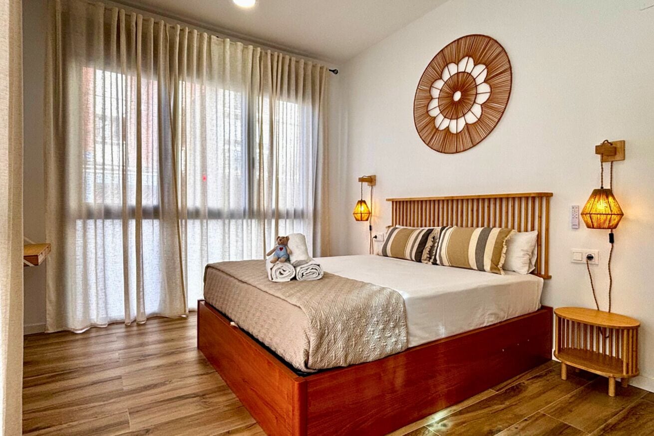 1 dormitorio y tabla de planchar con plancha