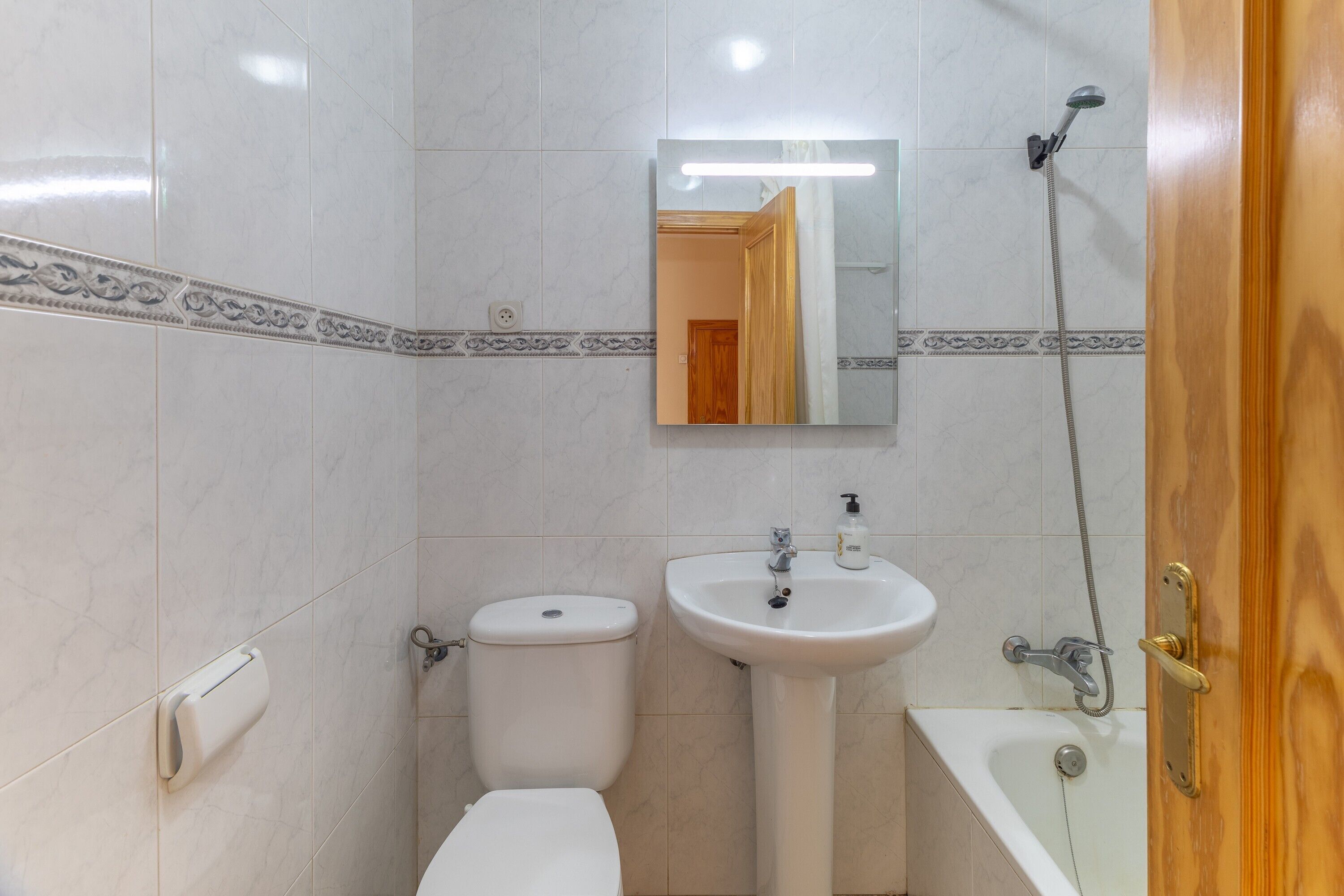 A bathroom with a toilet, sink, and bathtub.