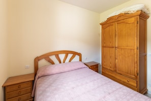 A bedroom with a wooden bed, a wooden nightstand, and a wooden wardrobe. - Lakeside House Alberche B - Lake Burguillo, Gredos Mountains (Ávila)