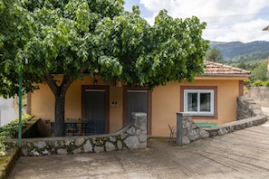Una casa con una escalera de piedra, una puerta y un ventanal.