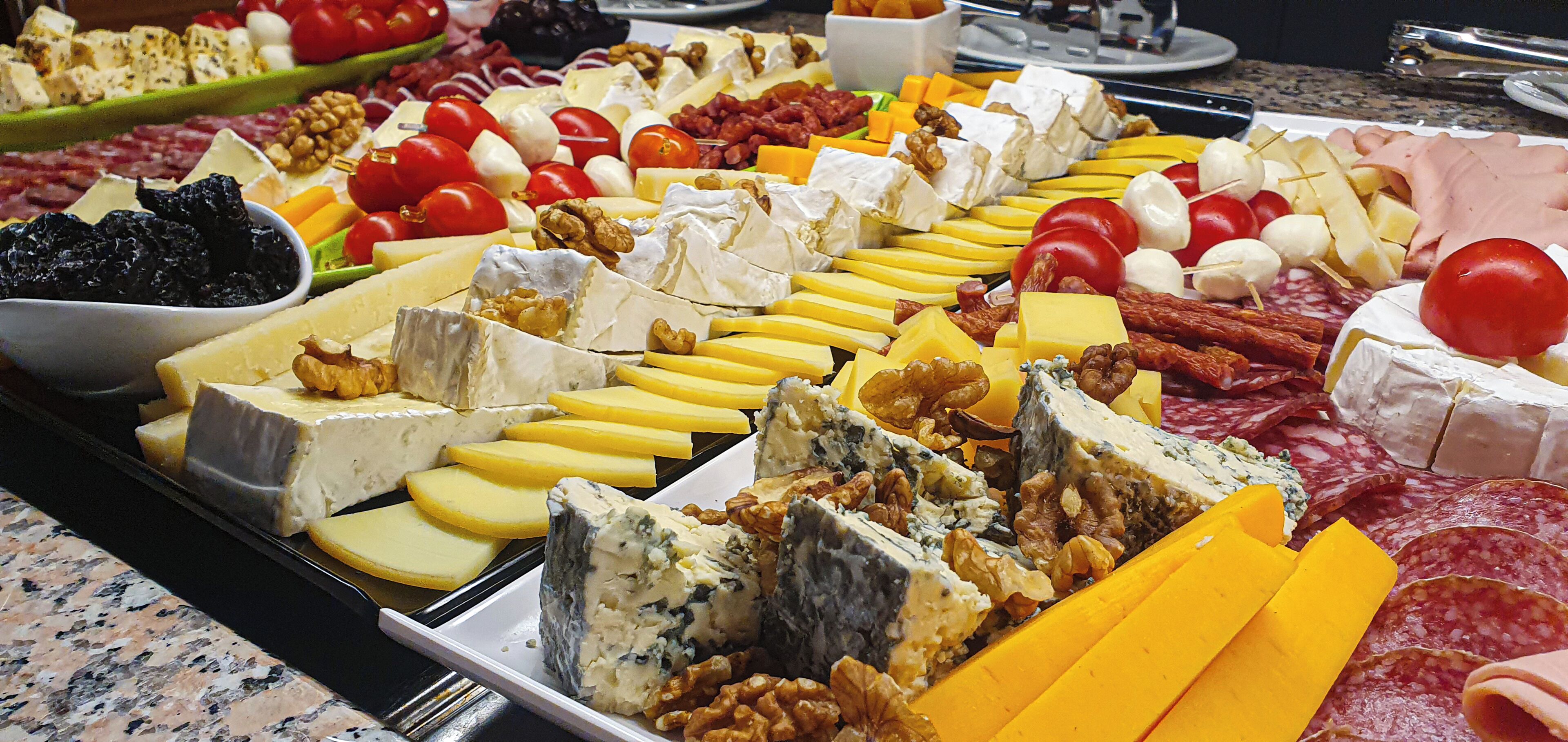A charcuterie board with various cheeses, nuts, and meats.