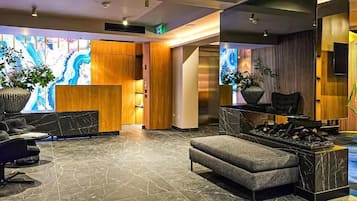 Una hall moderna con reception, area salotto e camino.