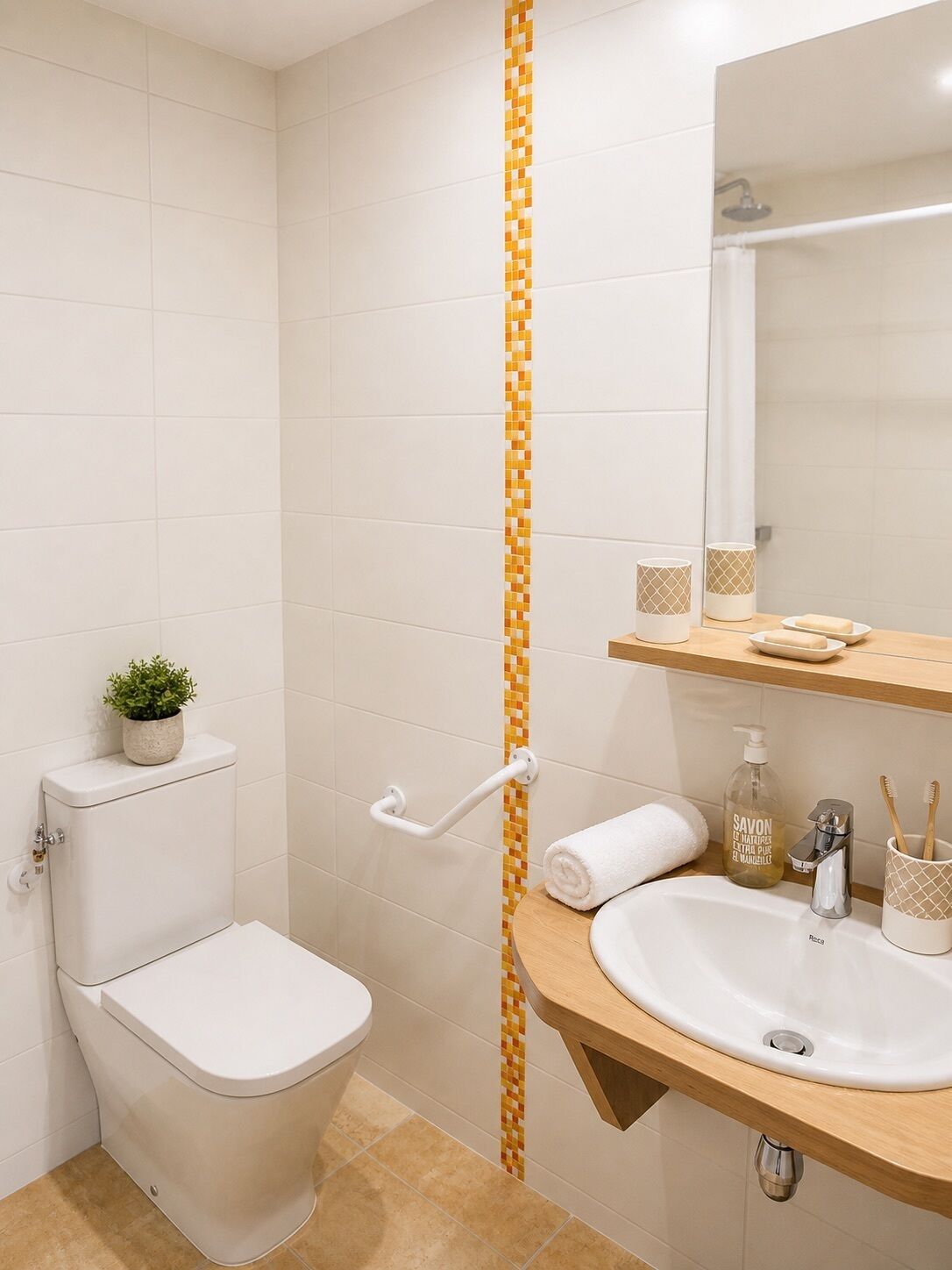 Un baño con inodoro, lavabo, espejo y ducha.