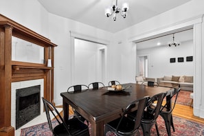 Ein Esszimmer mit Holztisch, Stühlen, Kamin und einer Chandelier.