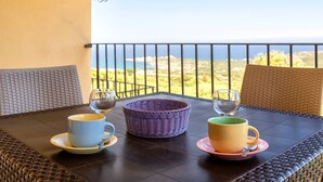 Ein Tisch mit zwei Tassen und einem Korb auf einem Balkon mit Blick auf eine schöne Aussicht.