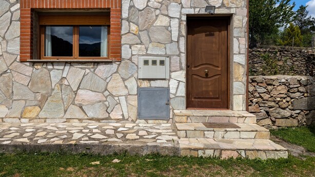 A stone building with a wooden door and window. - Holiday Home Paraíso Ground Floor - Lake Views, Gredos & Garden (Ávila)