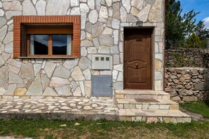 A stone building with a wooden door and window.