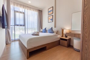 Quarto de hotel com cama, mesas de cabeceira, espelho e obras de arte na parede.