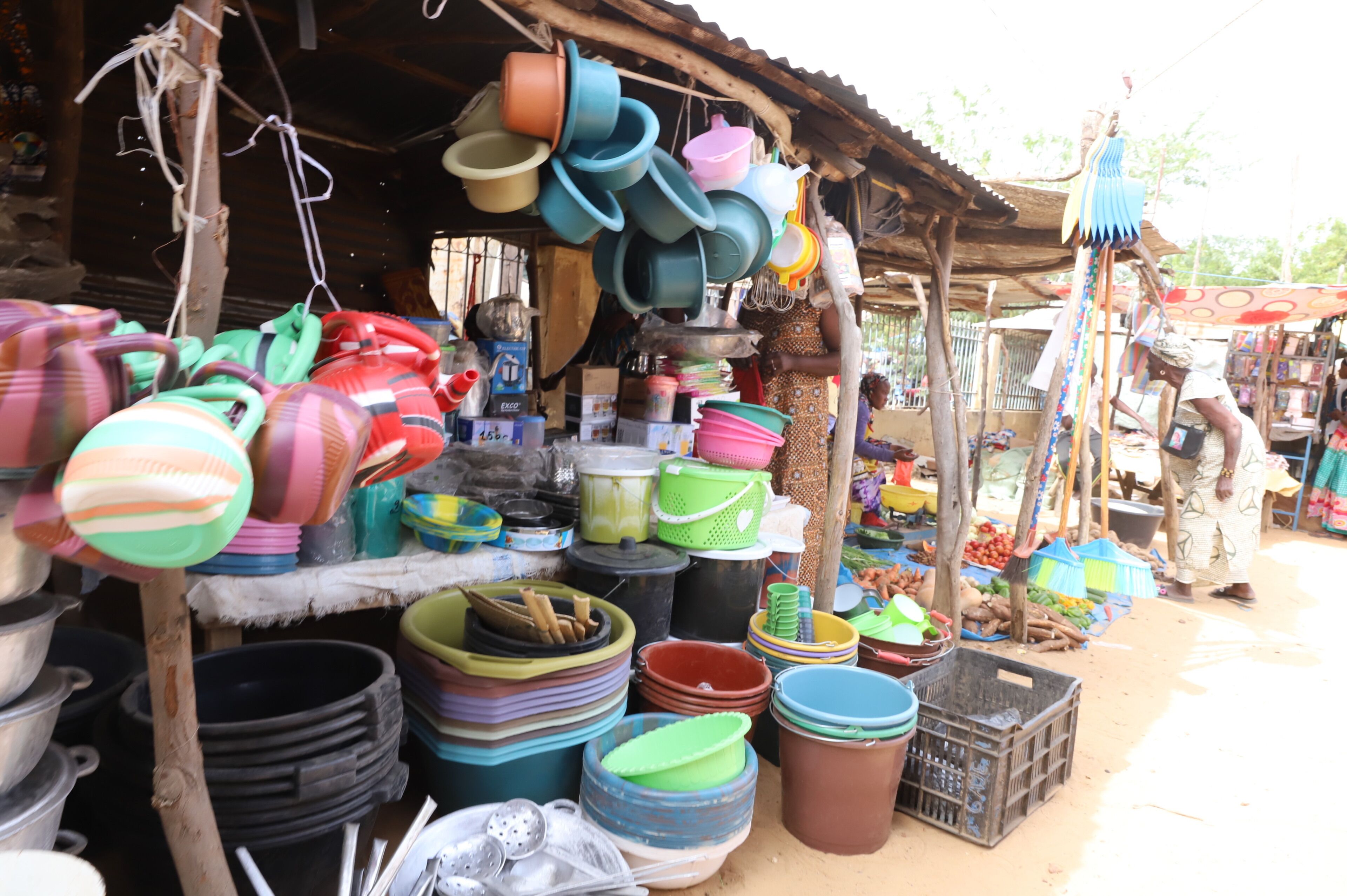A market stall with various plastic containers and household items.