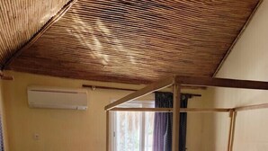 A single bed with a wooden frame, a desk with a chair, and a window with curtains. - A La Teranga (Foundiougne)