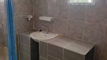 A bathroom with a sink, mirror, and tiled walls.
