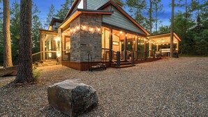 A stone building with a covered porch and a gravel driveway. - 2BR Family Retreat with Bunk Room and Hot Tub (Broken Bow)
