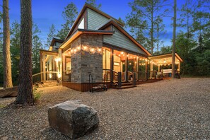 Ein Steinhaus mit einer überdachten Veranda und einer Schotterauffahrt.