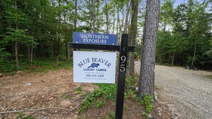 A sign for Blue Beaver Luxury Cabins with a contact number and website. - 2BR Family Retreat with Bunk Room and Hot Tub (Broken Bow)