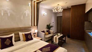 Een hotelkamer met een groot bed, een bank, een kleine tafel en een wand van hout.
