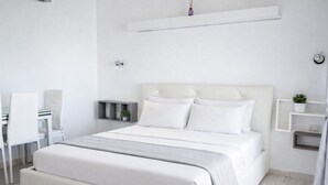Un dormitorio moderno con una cama grande, un escritorio y una silla.