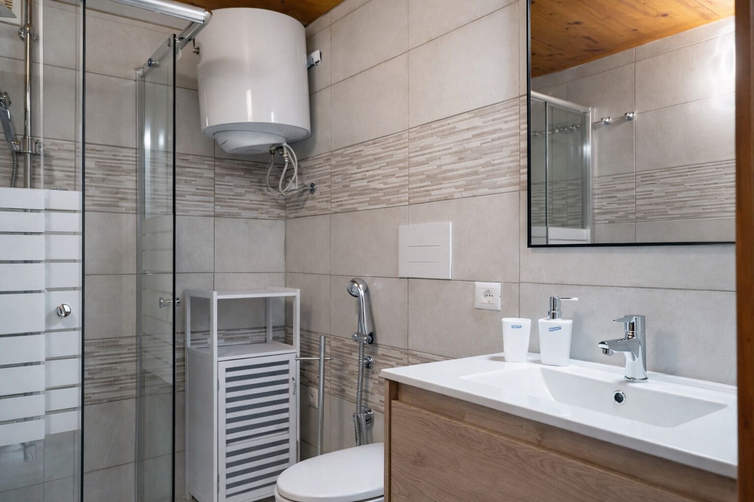 A modern bathroom with a shower, toilet, and sink.