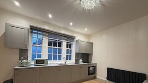 A modern kitchen with a window, built-in appliances, and a radiator.