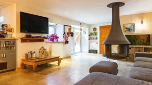 A living room with a fireplace, a television, and a sofa. - Bed and Breakfast 'Framboise' with Shared Terrace, Shared Garden and Wi-Fi (Belsentes)