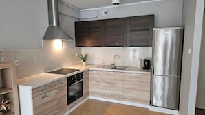 Una cocina moderna con campana extractora de acero inoxidable, horno empotrado, lavavajillas y refrigerador.