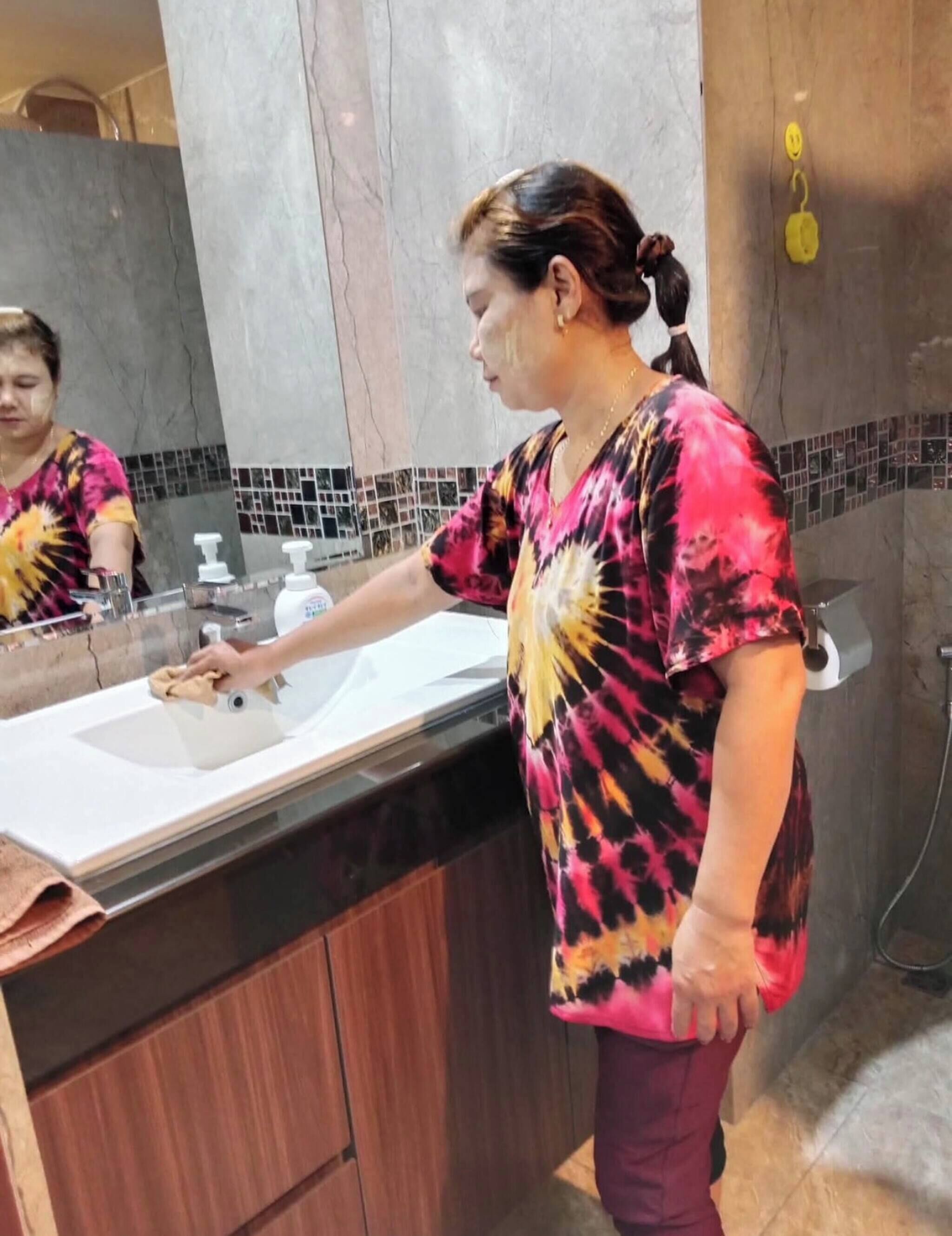 A bathroom with a marble sink, a mirror, and a shower area.