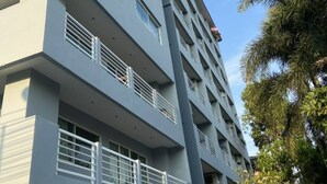 A multi-story building with balconies, air conditioning units, and a clear sky. - Large Condo Middle of Jomtien, Near the Beach 42m2 (Pattaya)