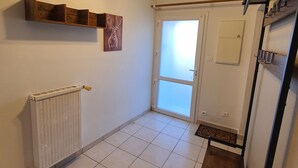 Ein Zimmer mit Heizkörper, einem Holzregal mit einem Hirschgemälde, einem Deckenventilator und einer Schiebetür.