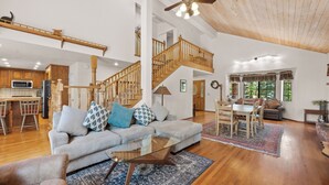 A spacious living area with a staircase, a dining table, and a kitchen area. - Modern Mountain Chalet w/ Hot Tub, Near the Slopes, Lake & Village (Big Bear Lake)