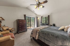 A bedroom with a large bed, a dresser, a chair, and a ceiling fan. - Modern Mountain Chalet w/ Hot Tub, Near the Slopes, Lake & Village (Big Bear Lake)