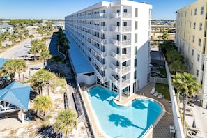 Ein mehrstöckiges Hotel mit Pool, Balkonen und Blick auf die Umgebung.