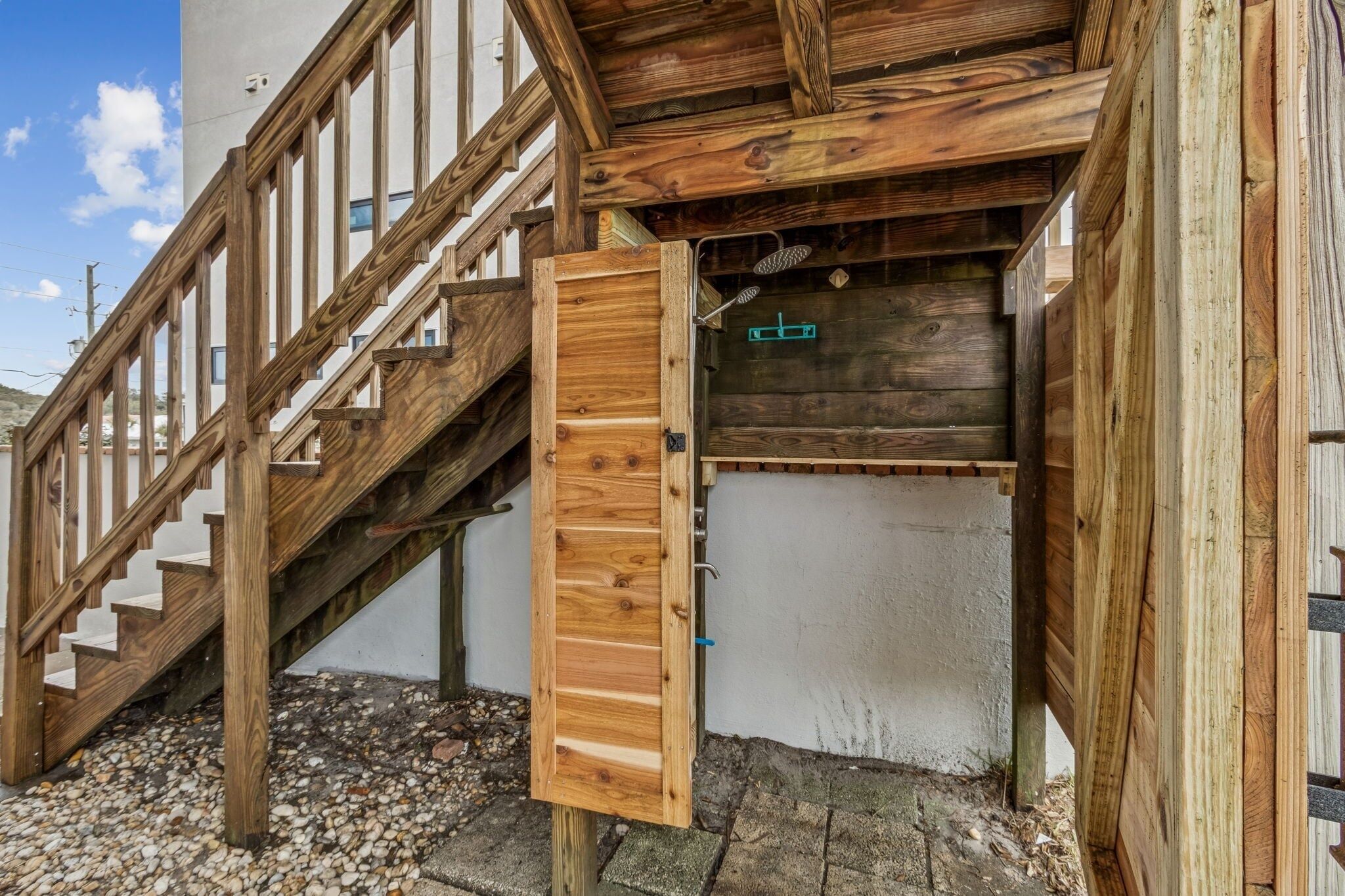 Un escalier en bois mène à une pièce dotée d’une porte en bois et d’une petite fenêtre.