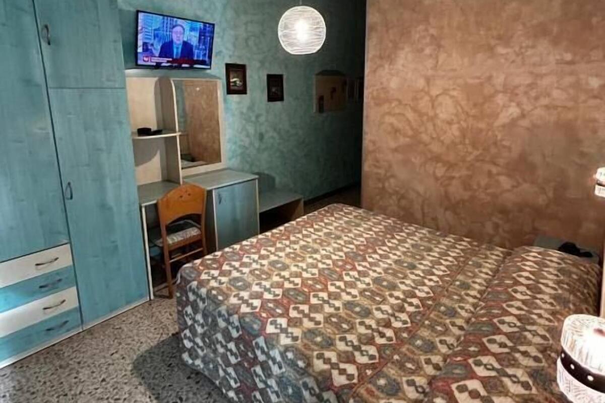 Makuuhuone, jossa on sänky, televisio, vaatekaappi ja työpöytä.