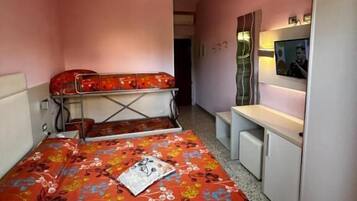 Un dormitorio con una cama litera, un escritorio, una silla y un televisor.
