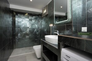 A modern bathroom with a large mirror, a white sink, and a shower area. - Villa Amore-4 Bedroom Villa with Private Pool (Alykes)