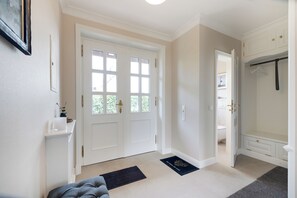 A hallway with a double door, a coat rack, a small rug, and a door mat. - Inselhüs on Sylt: family-friendly, 150 m², wood-burning stove & wellness facilities (Wenningstedt-Braderup (Sylt))