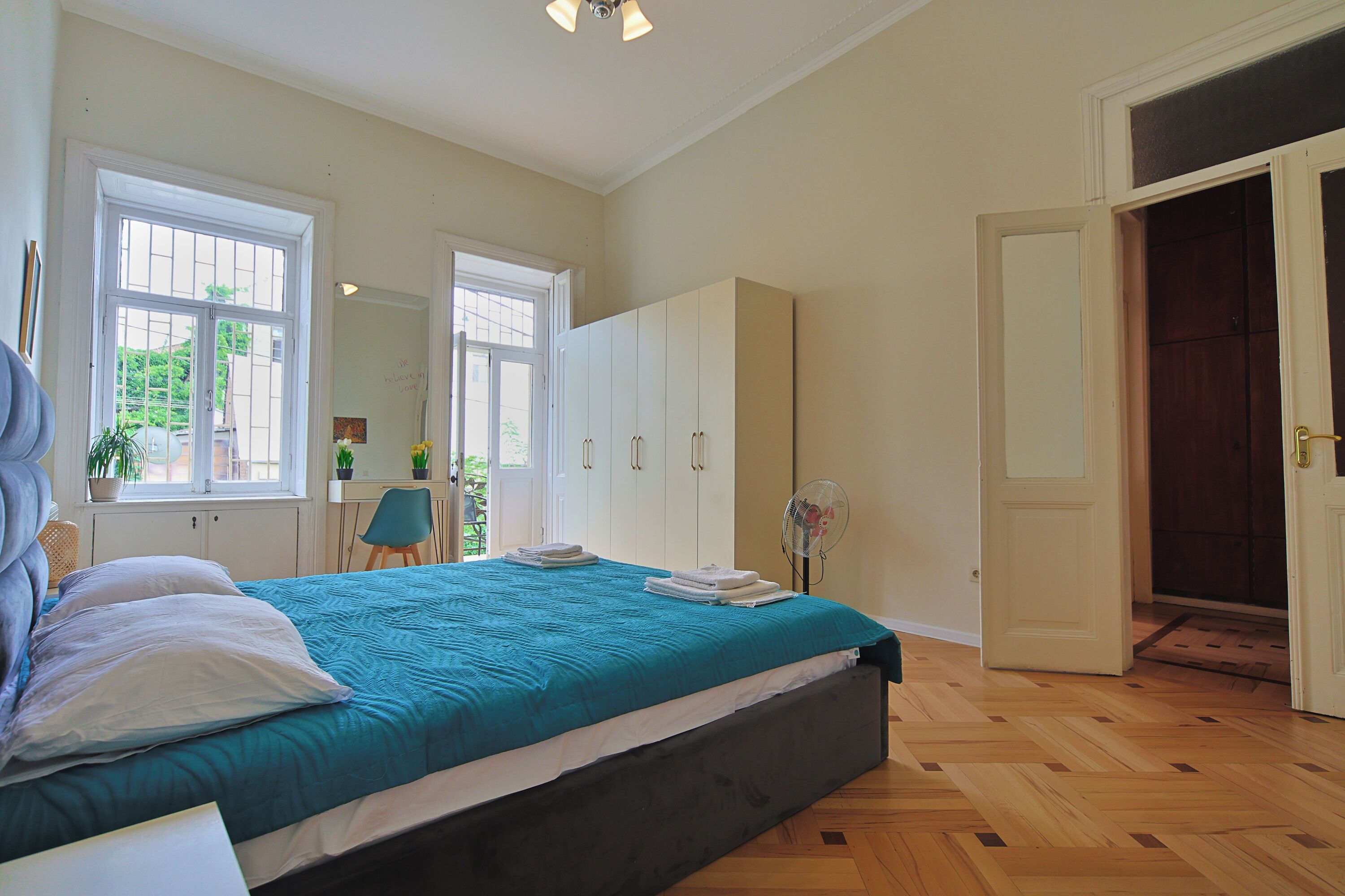 Une chambre à coucher avec un lit, un bureau, une chaise et une armoire.