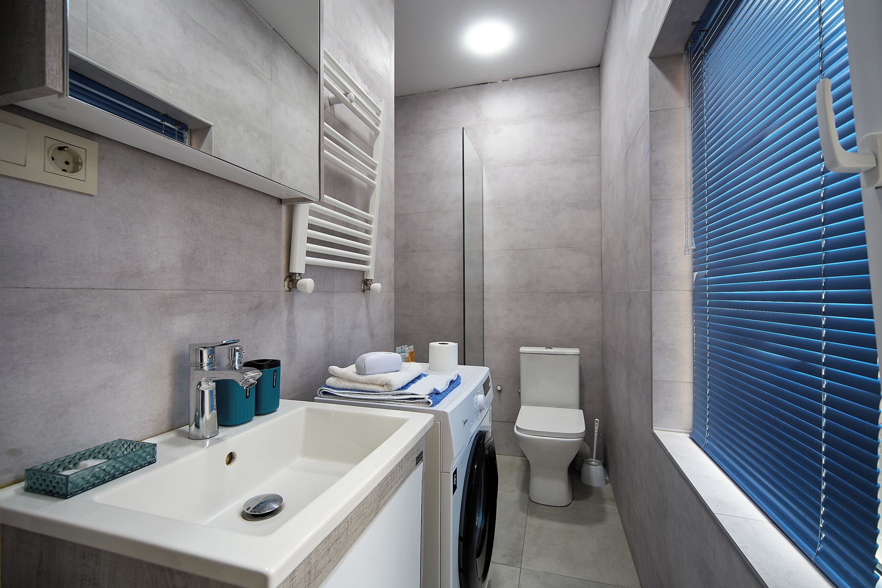 Un baño moderno con lavamanos, inodoro y ducha.