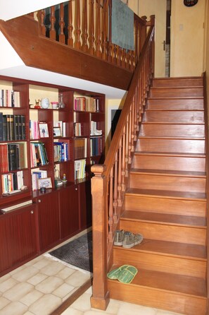 Un escalier en bois avec une bibliothèque sur le côté gauche.