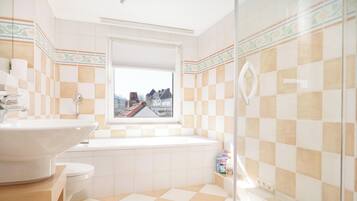 Un bagno con vasca, servizi igienici e lavandino.