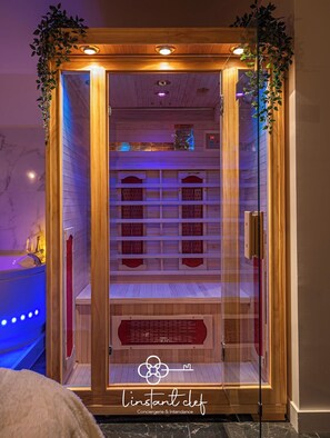A wooden room with a glass door, a red bench, and a logo on the door. - Love in The Jungle: Sauna, Jacuzzi & Private Parking (Le Mans)