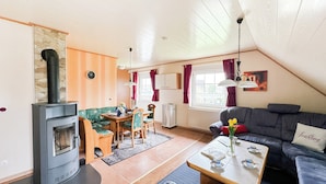 Una sala de estar acogedora con chimenea, comedor y sofá.