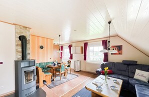 A cozy living room with a fireplace, a dining area, and a sofa. - Apartment Medemblick with canoe dock - Ihlienworth (Ihlienworth)